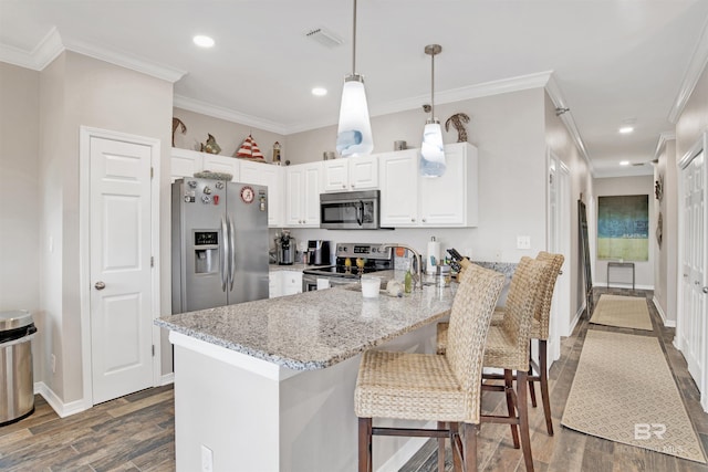 kitchen with stainless steel appliances, ornamental molding, a peninsula, and light stone countertops