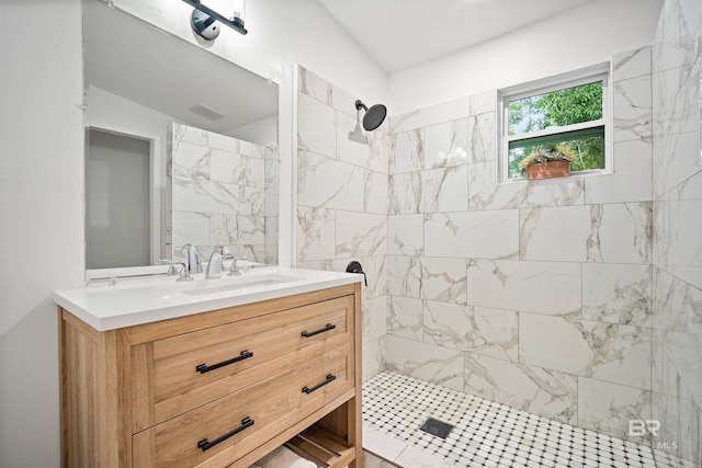 bathroom with tiled shower and vanity