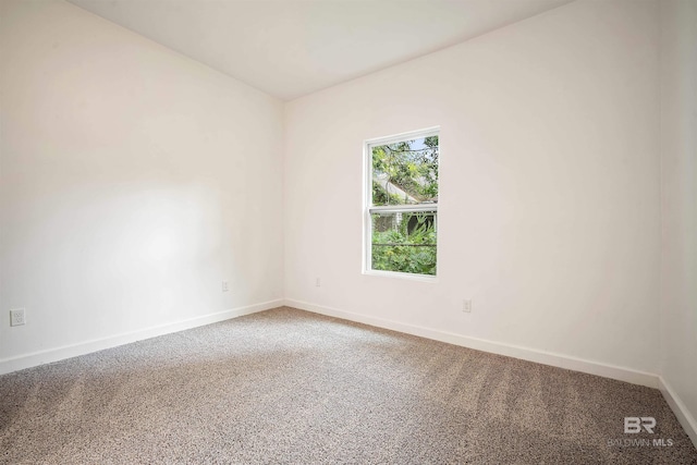 empty room featuring carpet and baseboards