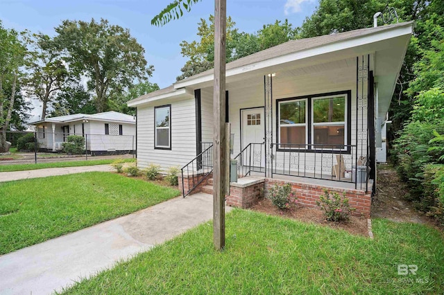 view of front of property featuring covered porch and a front lawn