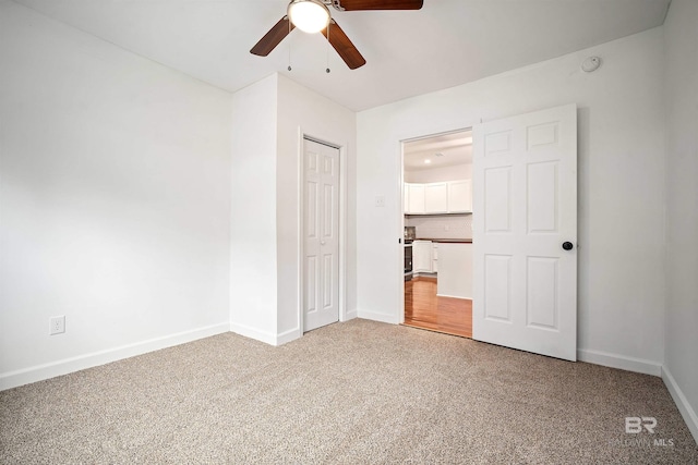 unfurnished bedroom featuring carpet floors, a closet, ceiling fan, and baseboards