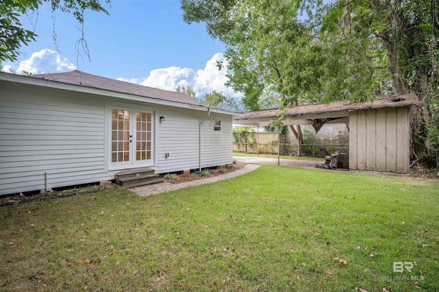 view of yard with french doors and fence