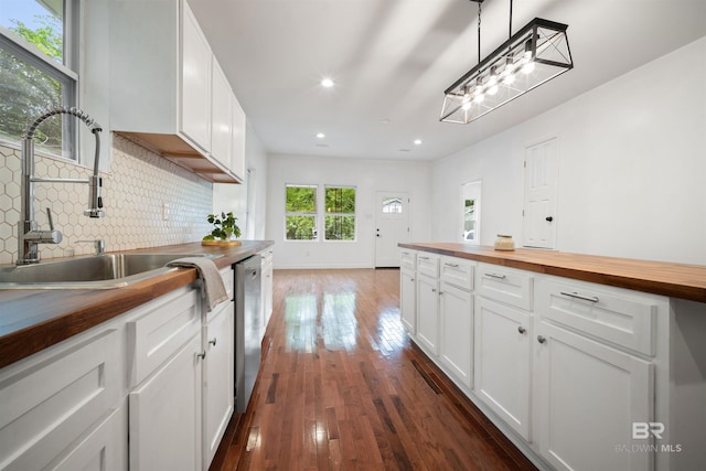 kitchen featuring dark wood-style floors, tasteful backsplash, a sink, butcher block countertops, and dishwasher