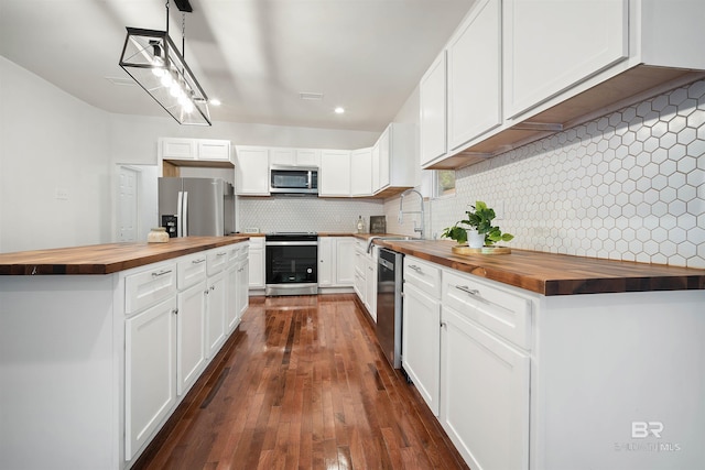 kitchen featuring dark wood-style floors, stainless steel appliances, wooden counters, backsplash, and a sink