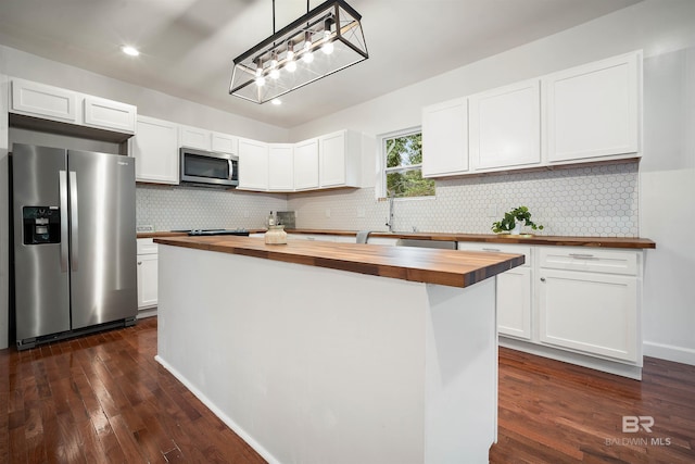 kitchen with white cabinetry, wood counters, appliances with stainless steel finishes, and a center island