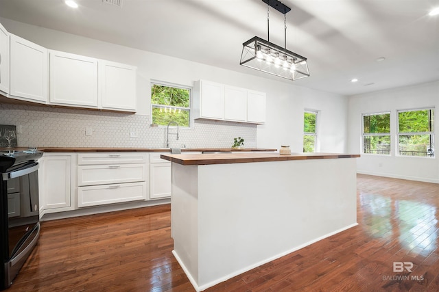 kitchen with stainless steel electric range oven, dark wood-style flooring, wood counters, and decorative backsplash