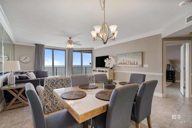 tiled dining area featuring ceiling fan with notable chandelier, ornamental molding, and a textured ceiling