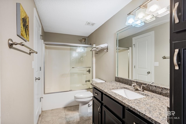 full bathroom with tile patterned floors, toilet, shower / bath combination with glass door, a textured ceiling, and vanity