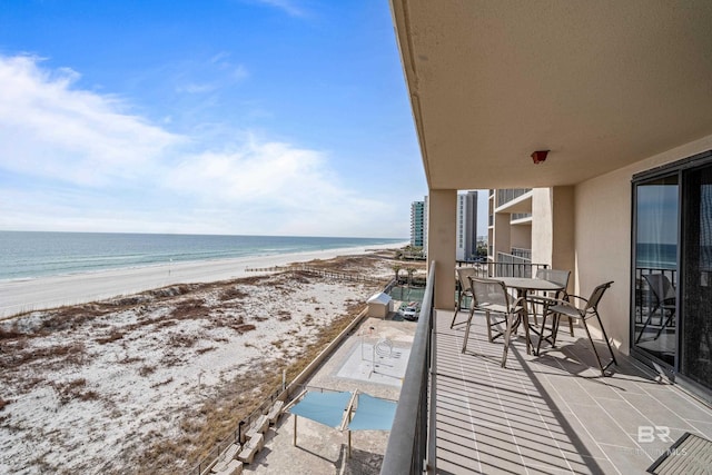 balcony with a water view and a beach view