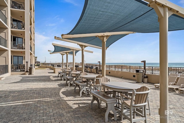 view of patio / terrace featuring a beach view and a water view