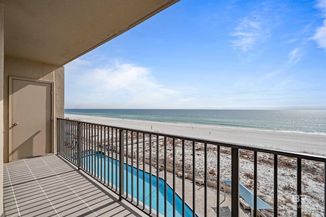 balcony with a water view and a beach view