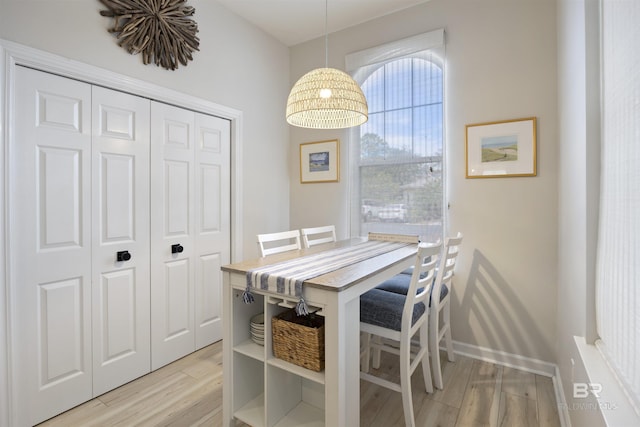 dining area with light wood-style flooring and baseboards