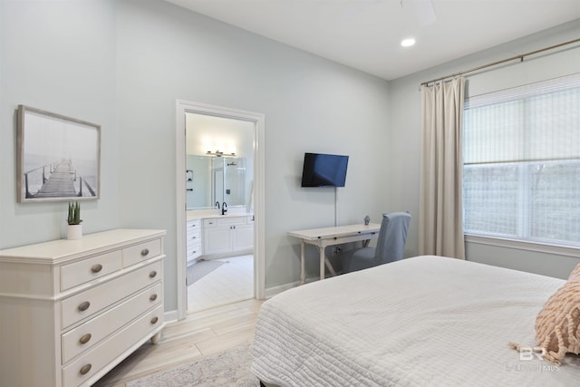 bedroom featuring ensuite bathroom, recessed lighting, a sink, baseboards, and light wood-style floors