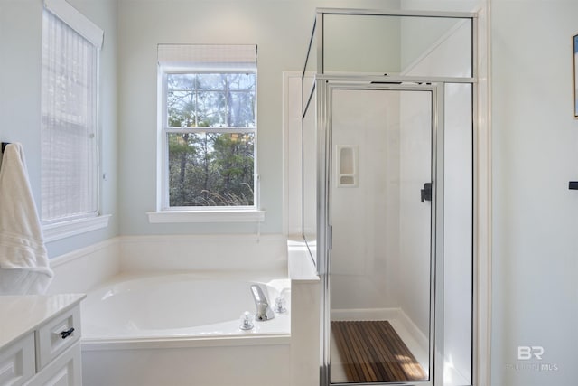 full bath with a stall shower, vanity, and a bath