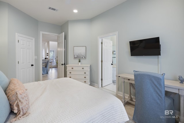 bedroom featuring recessed lighting, visible vents, light wood-style flooring, ensuite bath, and baseboards