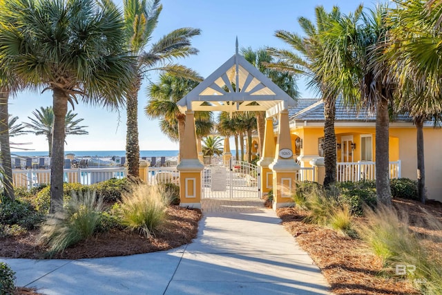 view of home's community featuring a fenced front yard, a gate, and a water view