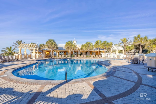 pool with a patio area and a pergola