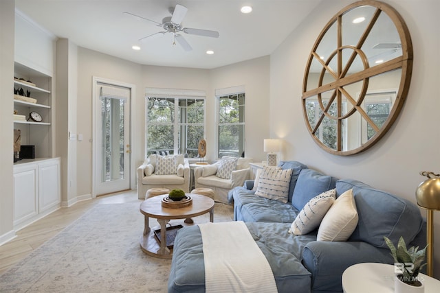 living area featuring light wood-style floors, ceiling fan, built in shelves, and recessed lighting