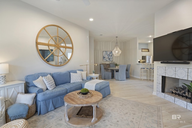 living room with baseboards, a tiled fireplace, wood finished floors, and recessed lighting