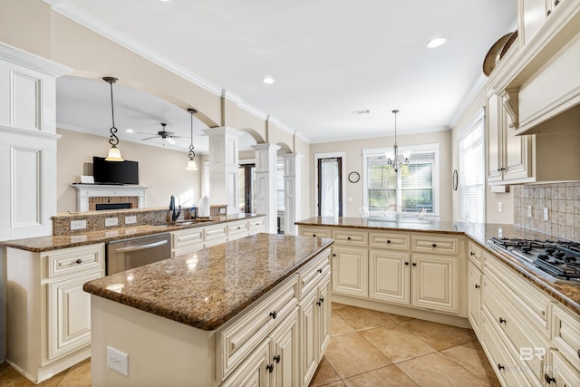 kitchen featuring stainless steel appliances, hanging light fixtures, kitchen peninsula, stone countertops, and a kitchen island