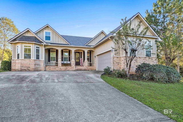 craftsman-style house featuring a front lawn, a porch, and a garage