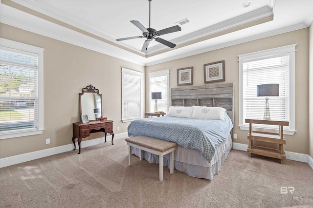 bedroom with a tray ceiling, multiple windows, crown molding, and ceiling fan