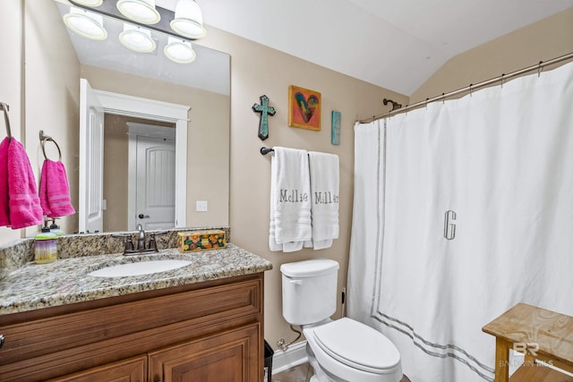 bathroom featuring vanity, toilet, and lofted ceiling