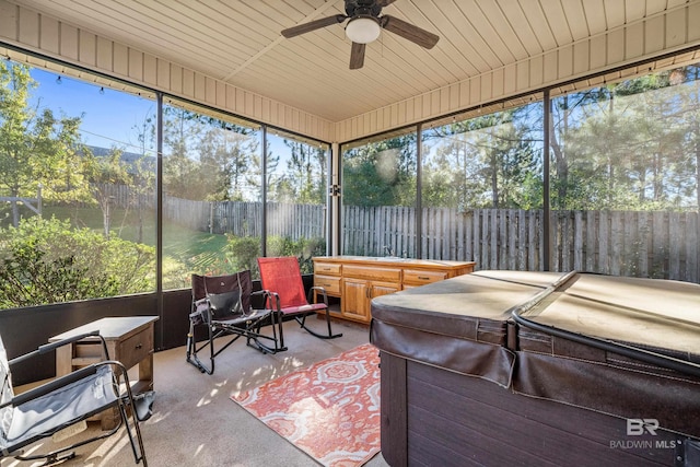 sunroom / solarium featuring ceiling fan, a wealth of natural light, and a hot tub