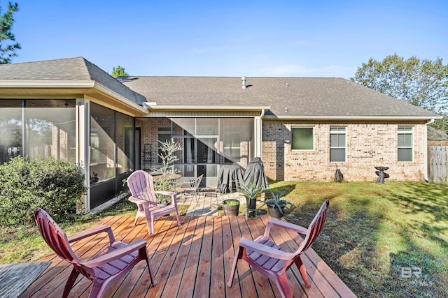 back of property featuring a lawn, a sunroom, and a deck