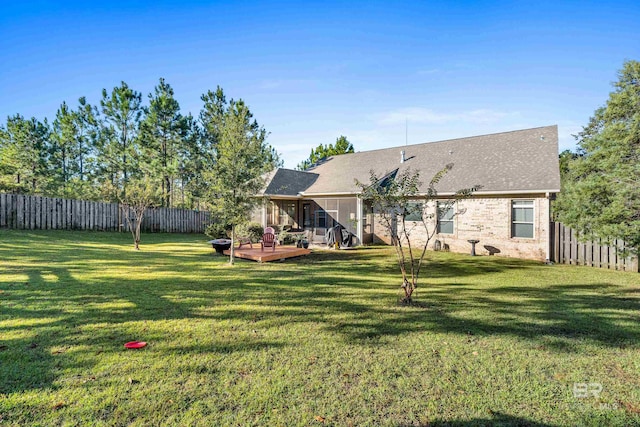 rear view of house featuring a lawn and a wooden deck