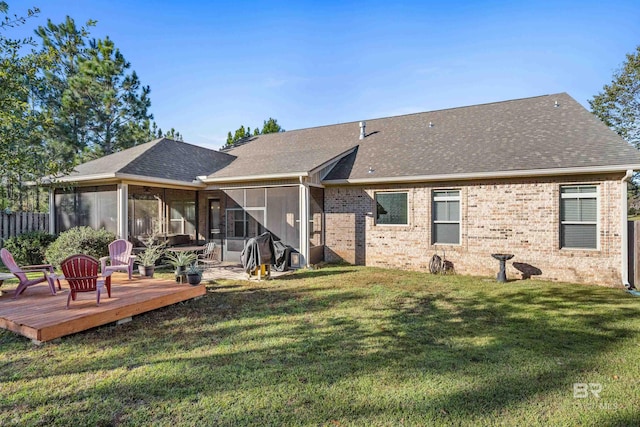 rear view of property with a sunroom, a deck, and a lawn