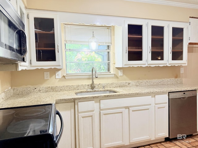 2371 Carriage Dr, Mobile, AL 36693 - kitchen with appliances with stainless steel finishes, glass insert cabinets, white cabinetry, light stone counters, and crown molding