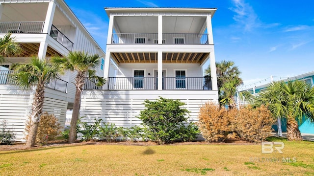 167 E J Cir, Gulf Shores, AL 36542 - raised beach house with a balcony, board and batten siding, and a front lawn