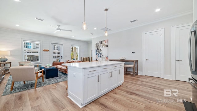 167 E J Cir, Gulf Shores, AL 36542 - kitchen with ornamental molding, plenty of natural light, light wood-type flooring, white cabinetry, and hanging light fixtures