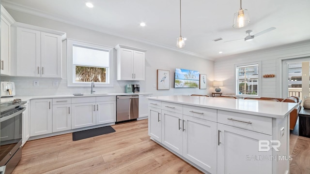 167 E J Cir, Gulf Shores, AL 36542 - kitchen with stainless steel appliances, ornamental molding, a sink, plenty of natural light, and light wood-type flooring