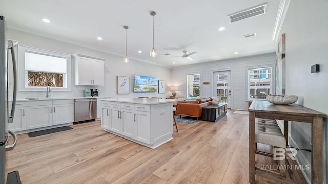 167 E J Cir, Gulf Shores, AL 36542 - kitchen with stainless steel appliances, light wood-style floors, open floor plan, a ceiling fan, and light countertops