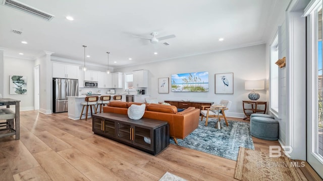 167 E J Cir, Gulf Shores, AL 36542 - living area featuring recessed lighting, light wood-style floors, baseboards, a ceiling fan, and crown molding