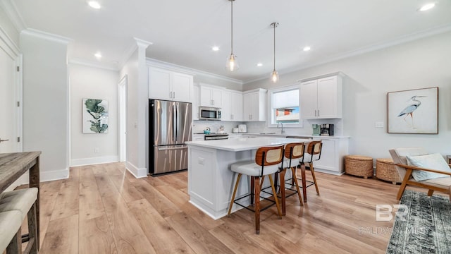 167 E J Cir, Gulf Shores, AL 36542 - kitchen with stainless steel appliances, a breakfast bar, ornamental molding, white cabinetry, and backsplash