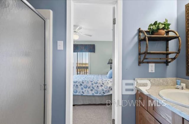 bathroom featuring a shower with door, vanity, and ceiling fan