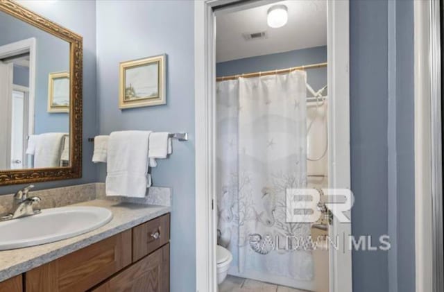 bathroom featuring vanity, curtained shower, tile patterned floors, and toilet