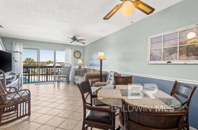 tiled dining room featuring a textured ceiling and ceiling fan