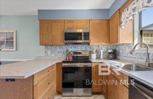 kitchen with light tile patterned flooring, tasteful backsplash, sink, kitchen peninsula, and stainless steel appliances