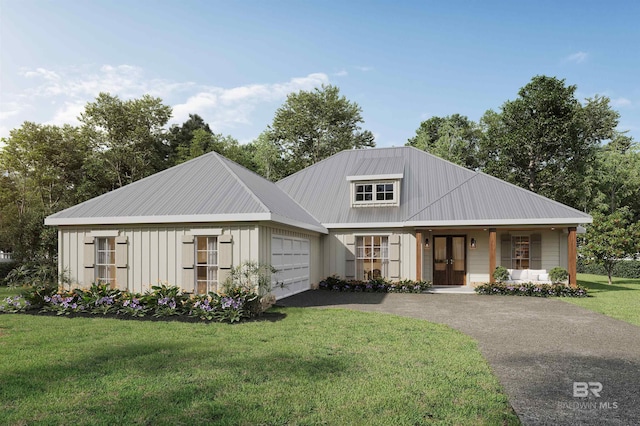 view of front facade with aphalt driveway, metal roof, an attached garage, a front lawn, and a porch