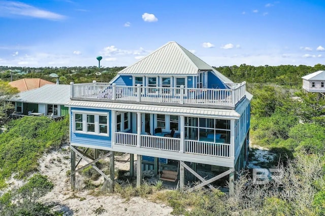 back of house with a sunroom and a balcony