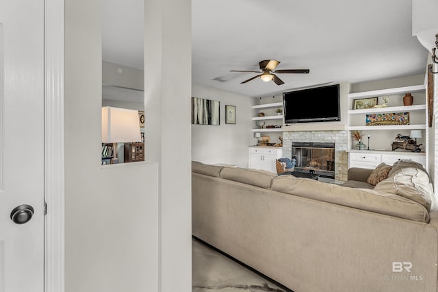 23214 Rochelle Loop, Robertsdale, AL 36567 - living room featuring a glass covered fireplace, ceiling fan, and concrete flooring