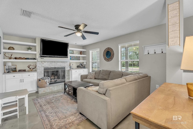 23214 Rochelle Loop, Robertsdale, AL 36567 - living area with ceiling fan, a fireplace, concrete flooring, and a textured ceiling
