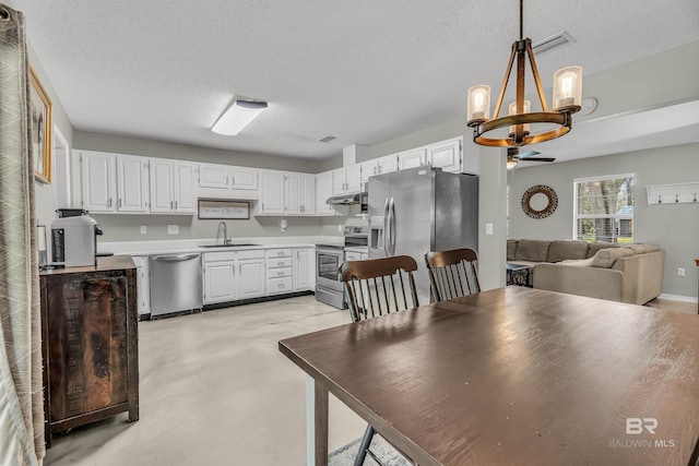 23214 Rochelle Loop, Robertsdale, AL 36567 - kitchen featuring stainless steel appliances, a chandelier, under cabinet range hood, a textured ceiling, and white cabinetry