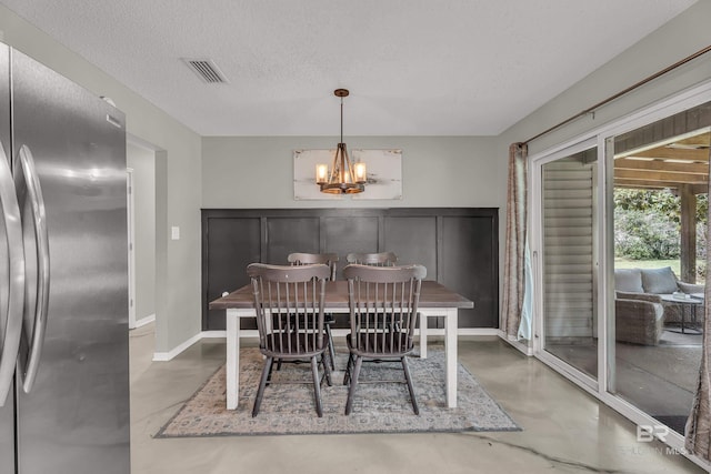 23214 Rochelle Loop, Robertsdale, AL 36567 - dining room with concrete flooring, a chandelier, and a textured ceiling