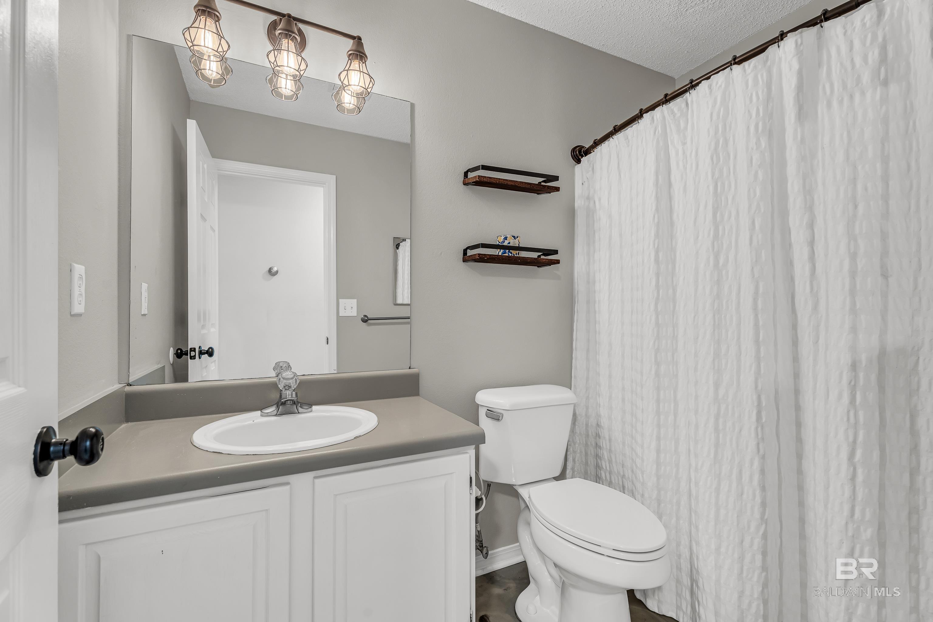 23214 Rochelle Loop, Robertsdale, AL 36567 - bathroom featuring vanity and a textured ceiling