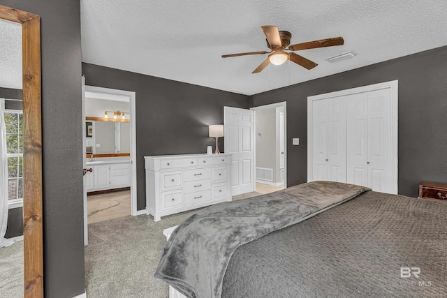 23214 Rochelle Loop, Robertsdale, AL 36567 - bedroom featuring light colored carpet, a textured ceiling, a closet, a ceiling fan, and connected bathroom